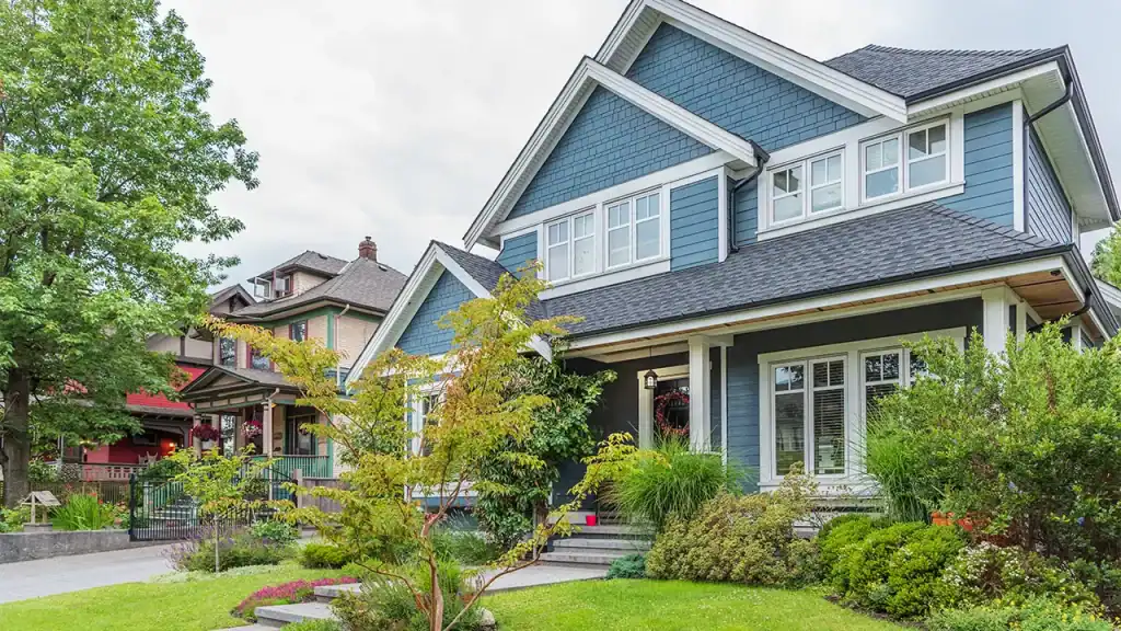Blue two-story house, white trim, porch, lawn; pest-free.